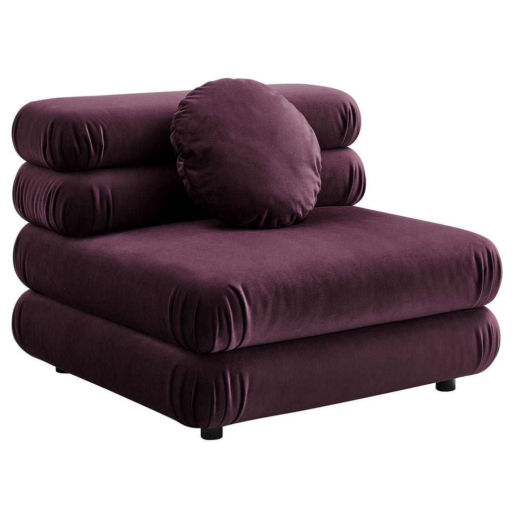 Deep plum velvet armless chair with stacked, rounded cushions and a round bolster pillow, shown against a white background