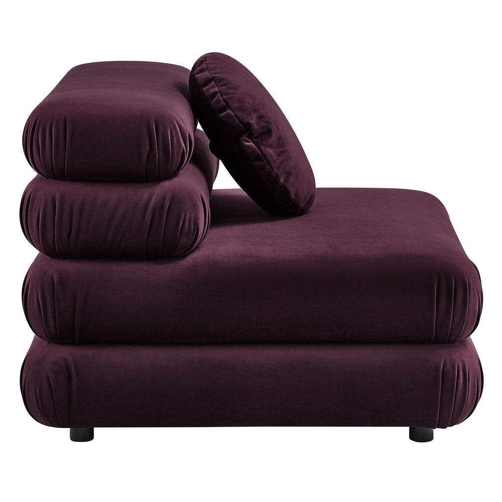 Side view of the deep plum velvet armless chair showing its stacked cushion construction and rounded bolster pillow