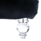 Close-up of the Rochelle Chaise's faceted, crystal-clear acrylic foot beneath black velvet upholstery