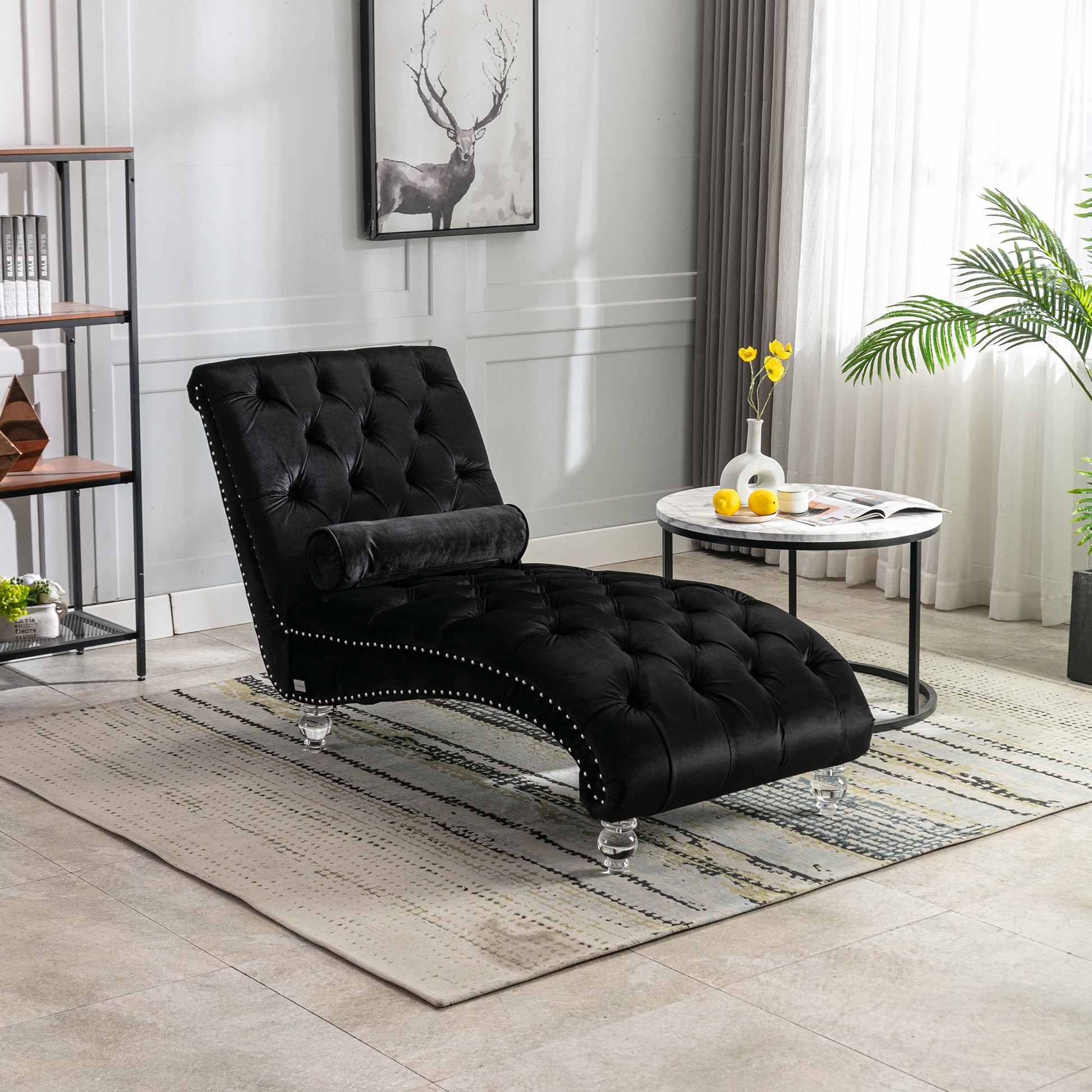 Black velvet Rochelle chaise lounge with acrylic feet styled in a neutral living room beside a marble side table