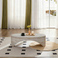 Symmetrical front elevation view of the low-profile Voûte Coffee Table in a modern living room showcasing the clean negative space under its structural arch.