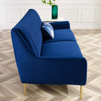 Navy velvet sofa styled in a living room, showing channel-tufted backrest and gold-leg base