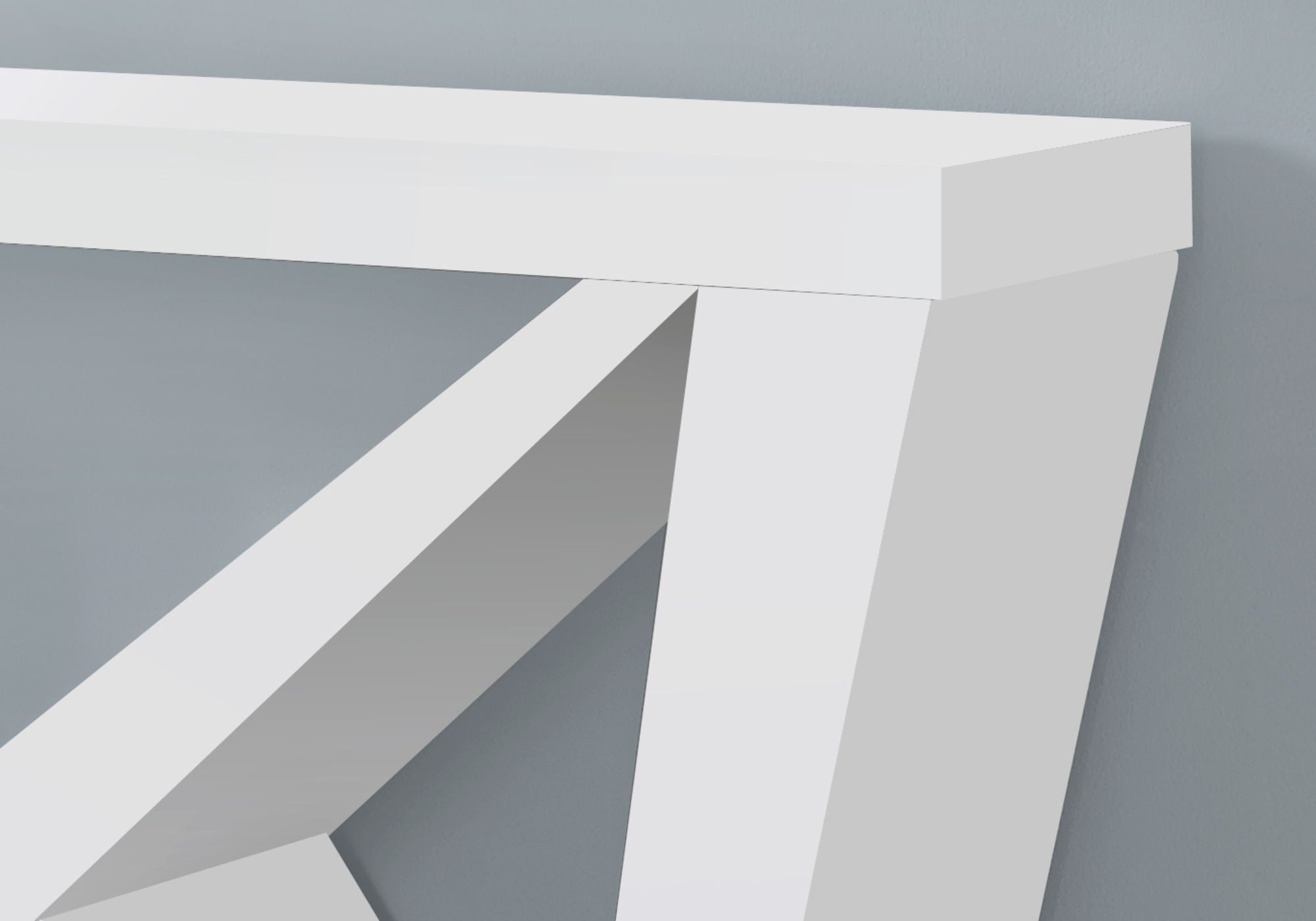 Close-up of white console table corner showing wedge leg construction and tabletop thickness