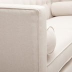 Close-up profile view of the crisp shelter track arm on the Cadence beige sofa, showcasing the tight, professional piping lines and structured fabric wrap.