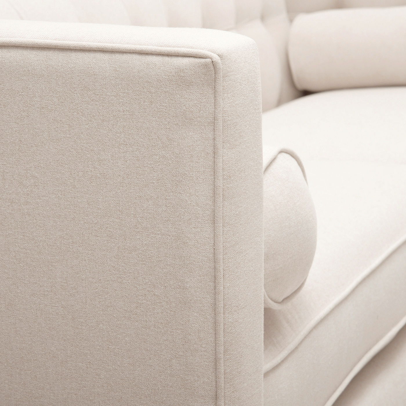 Close-up profile view of the crisp shelter track arm on the Cadence beige sofa, showcasing the tight, professional piping lines and structured fabric wrap.
