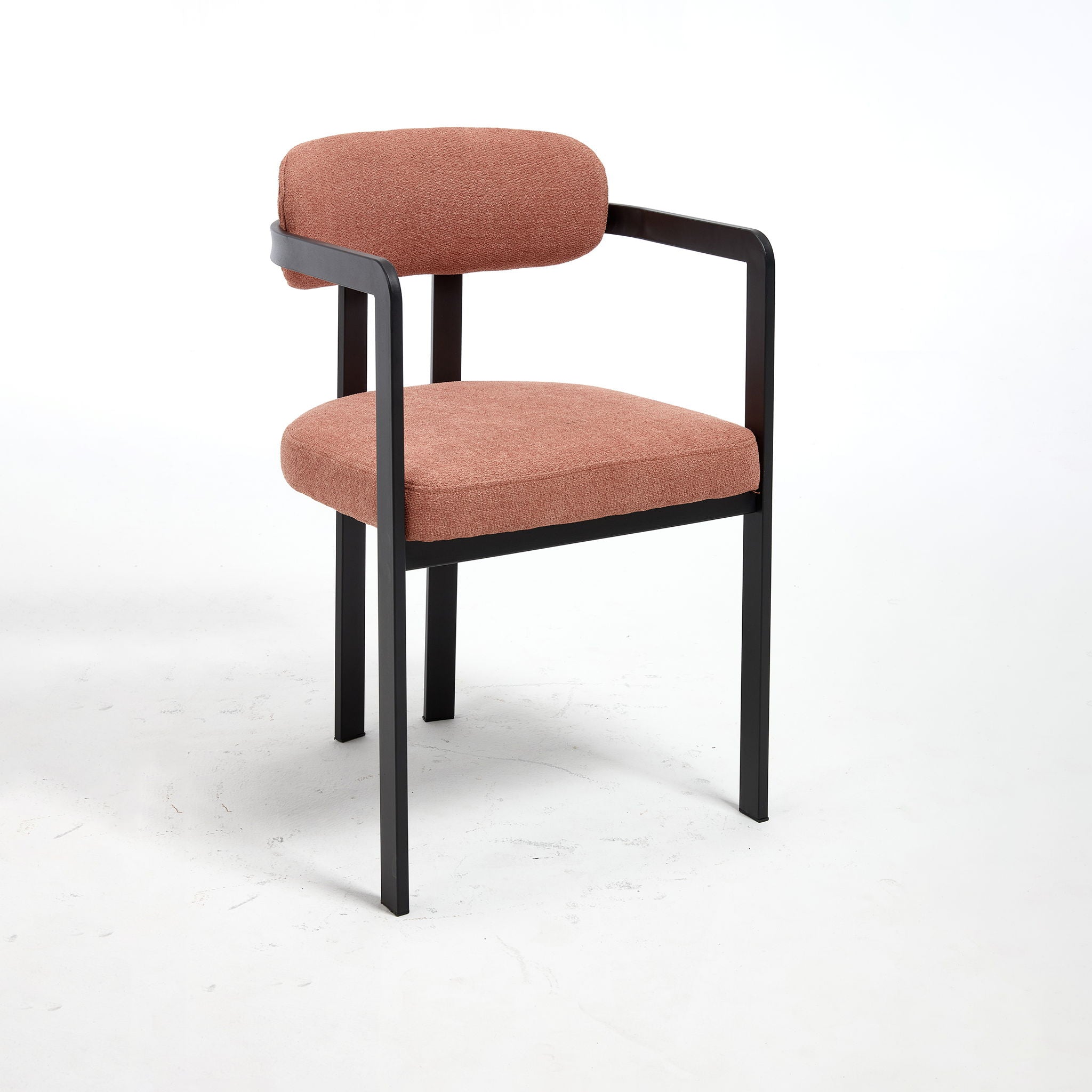 Three-quarter studio angle of the Helix dining chair wrapped in a finely textured terracotta orange upholstery, highlighting the continuous geometric profile and floating backrest cushion.