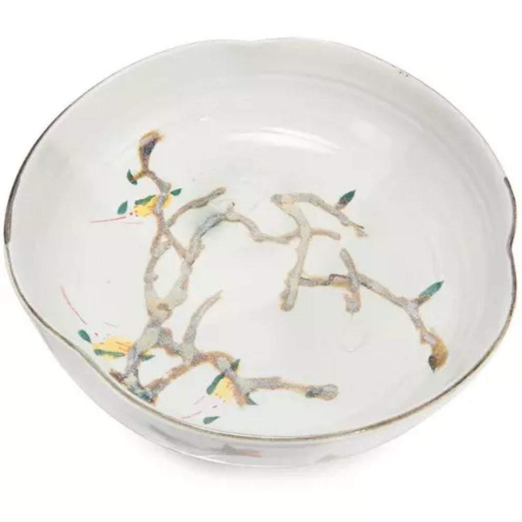 Nadine Bowl in glossy ivory ceramic with an organic branch motif in soft brown, green, and gold tones, shown from an angled overhead view.