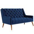 Low three-quarter studio perspective of the Peruse velvet loveseat in navy blue, emphasizing the depth of the tufted backrest profile and sloped arm track geometry.