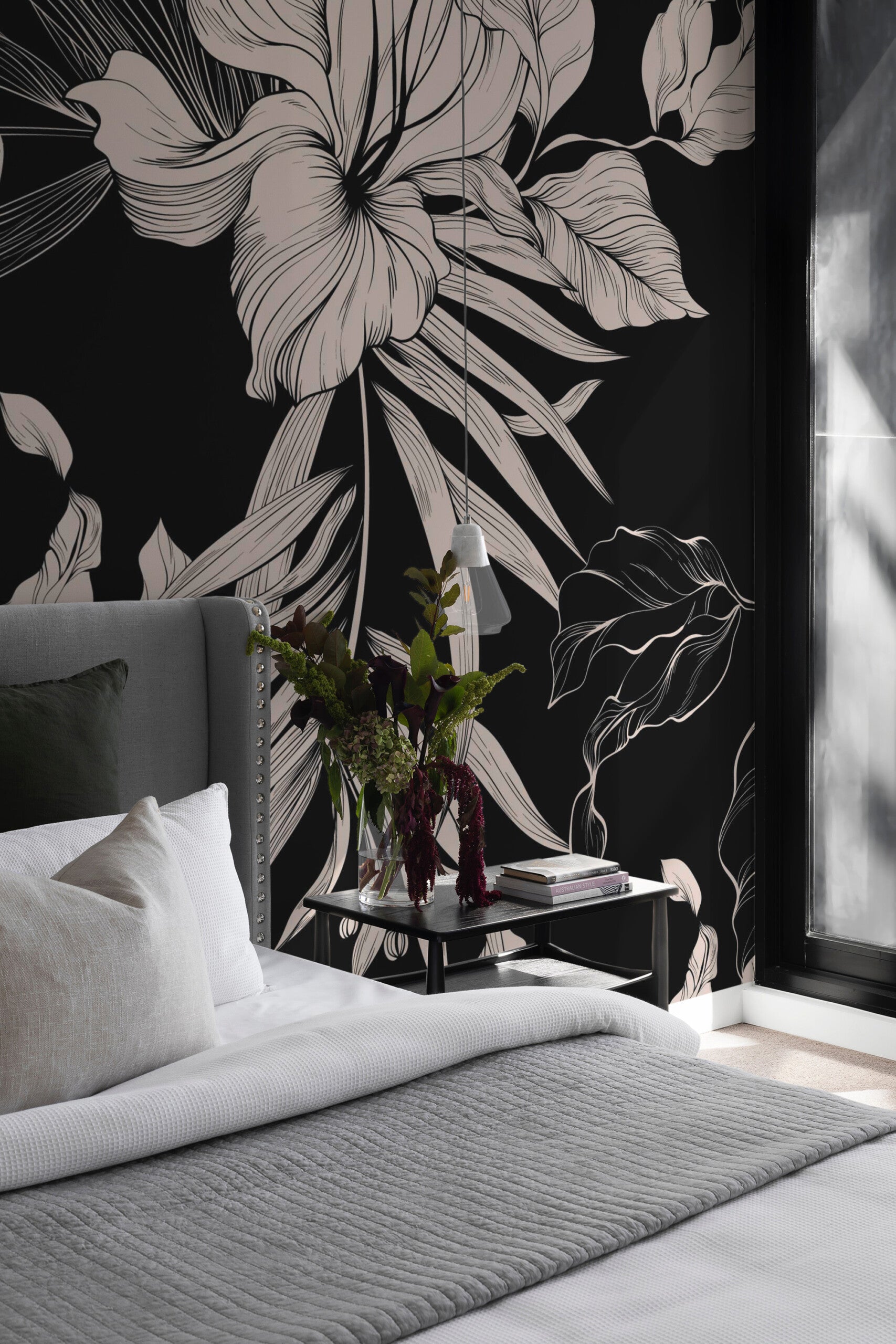 Bedroom with black and ivory Sidonie botanical wall mural behind a gray upholstered bed and black bedside table.