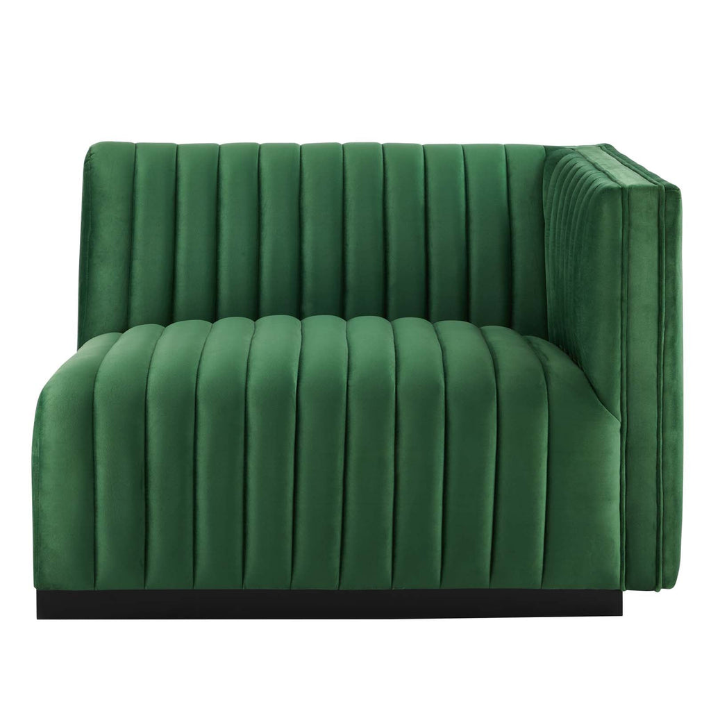Clean three-quarter studio presentation of the Velvet Rogue emerald green velvet loveseat, highlighting the continuous vertical channel tufting and the hidden black plinth base against a white backdrop.