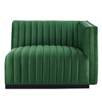 Clean three-quarter studio presentation of the Velvet Rogue emerald green velvet loveseat, highlighting the continuous vertical channel tufting and the hidden black plinth base against a white backdrop.