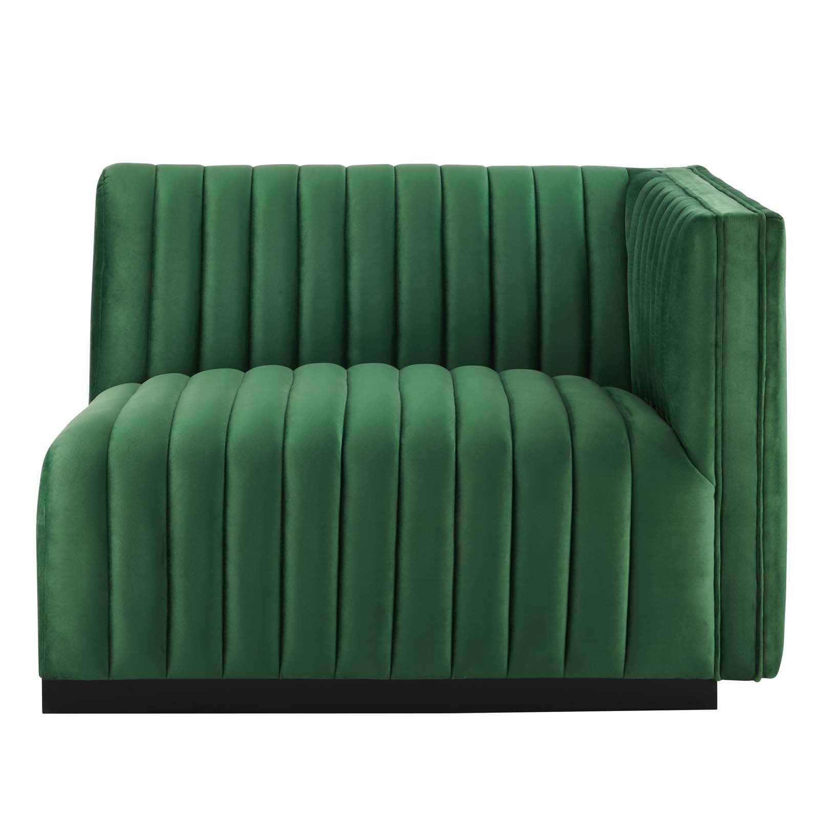 Clean three-quarter studio presentation of the Velvet Rogue emerald green velvet loveseat, highlighting the continuous vertical channel tufting and the hidden black plinth base against a white backdrop.