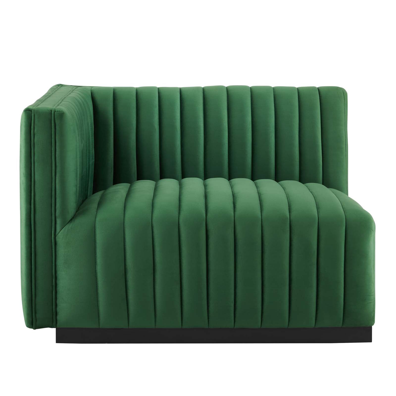 Clean three-quarter studio presentation of the Velvet Rogue emerald green velvet loveseat, highlighting the continuous vertical channel tufting and the hidden black plinth base against a white backdrop.